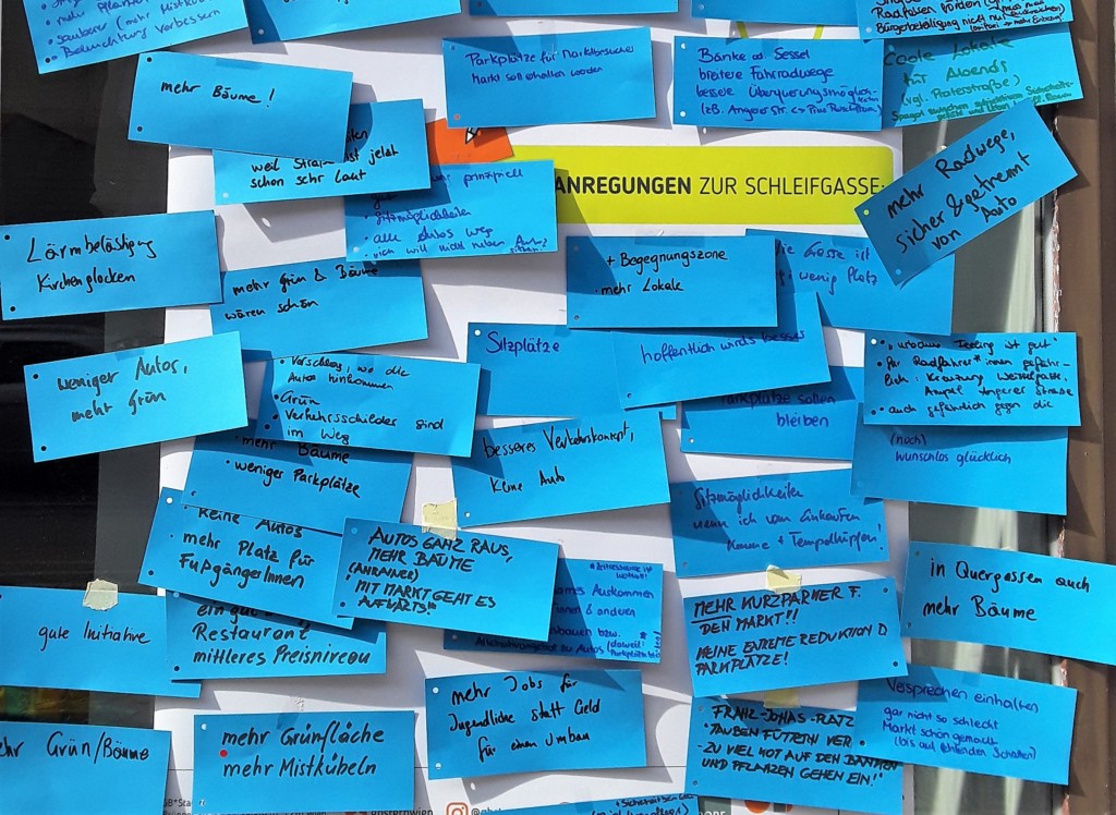 Zettel mit verschiedenen handgeschriebenen Vorschlägen kleben auf einem großen Plakat.