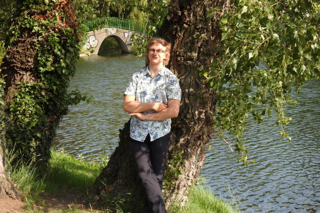 Junger Mann vor einem Baum