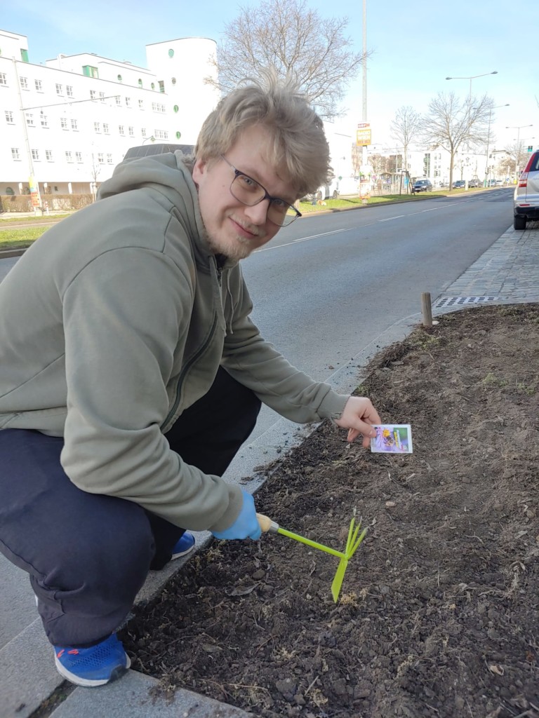 junger Mann sät Blumensamen in der Erde an