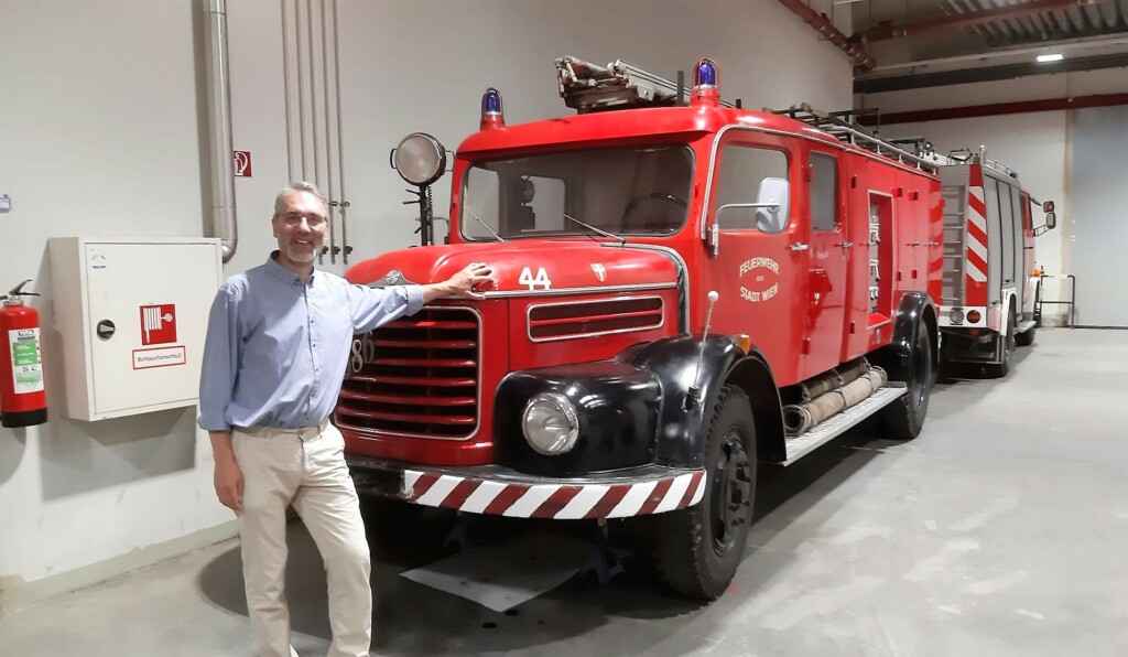 Mann steht vor einem älteren Feuerwehrauto