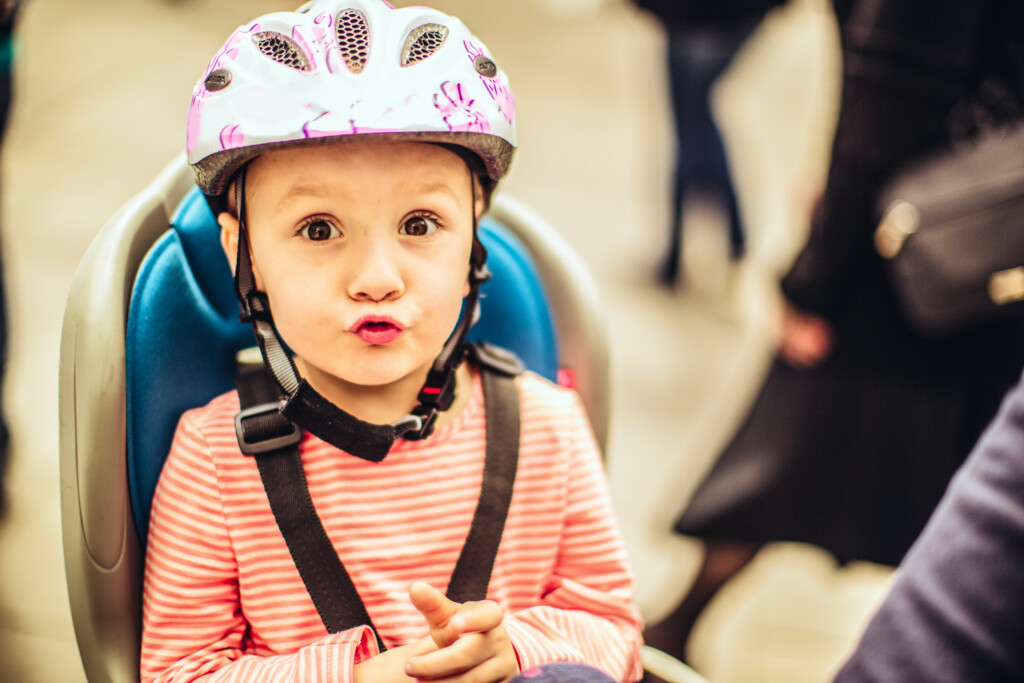Kind mit Helm sitzt auf einem Fahrradsitz