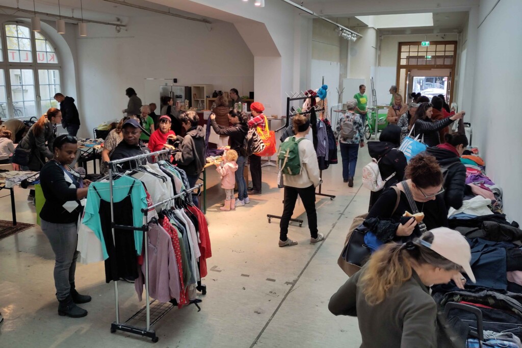 Viele Menschen in einem Raum mit vielen Kleidungsstücken.